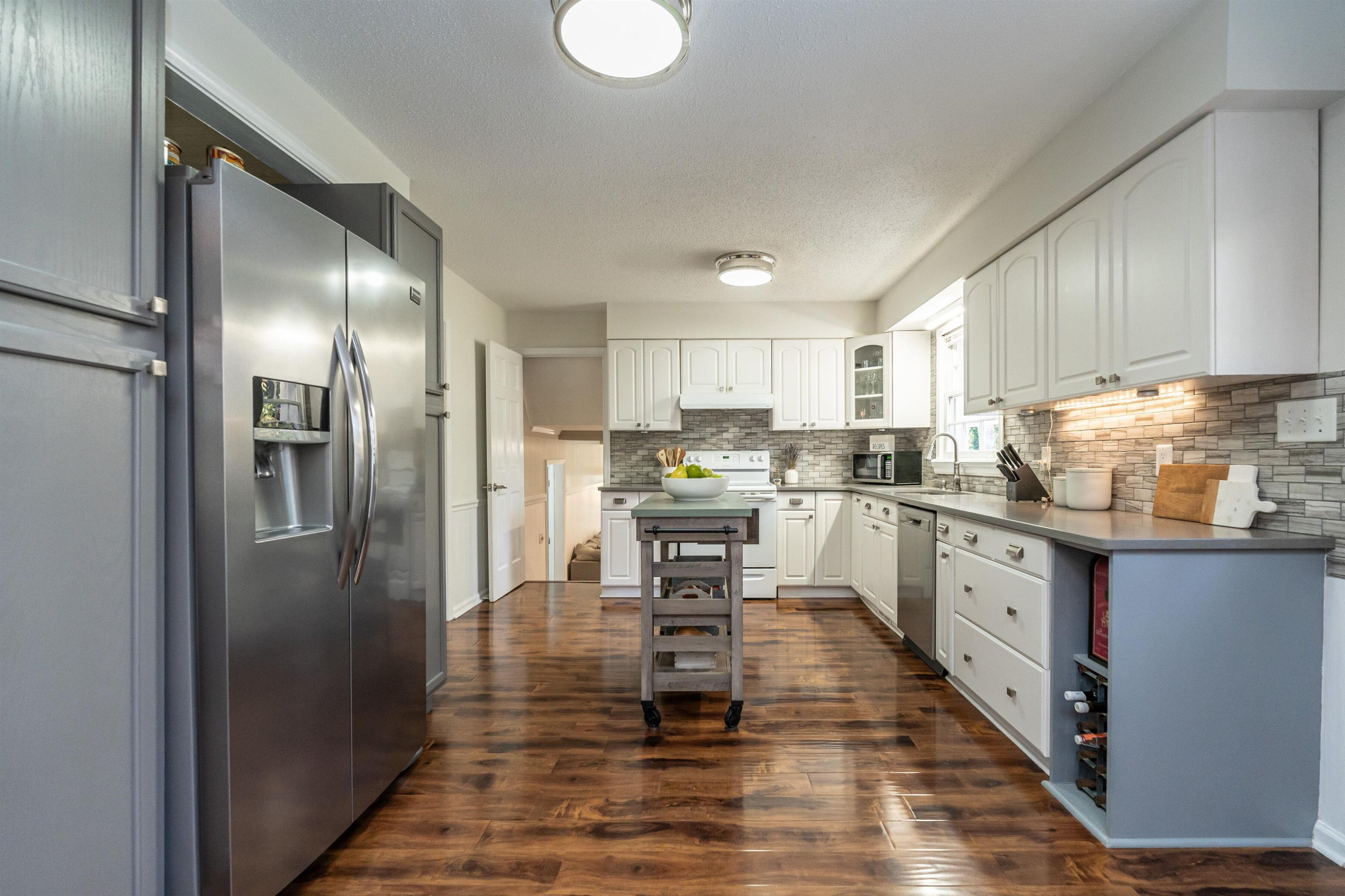 4305 Old Colony Road Raleigh, NC 27613 - Photo 11 of 33 a kitchen with stainless steel appliances granite countertop a refrigerator sink and cabinets