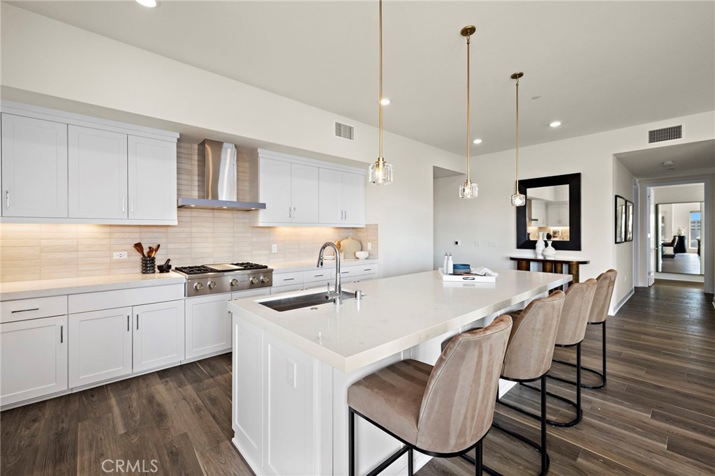 1500 Rivington Irvine, CA 92612 - Photo 9 of 37 a kitchen with stainless steel appliances a stove a sink a dining table and chairs