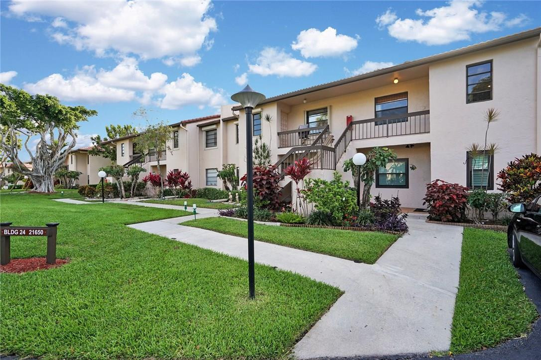 21650 Juego Circle, Unit 24F Boca Raton, FL 33433 - Photo 1 of 24 a front view of house with yard