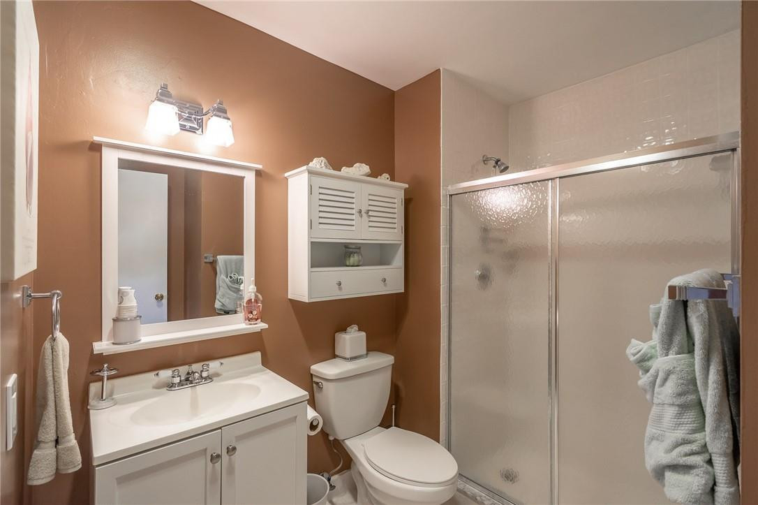 21650 Juego Circle, Unit 24F Boca Raton, FL 33433 - Photo 13 of 24 a bathroom with a sink a toilet a mirror and shower