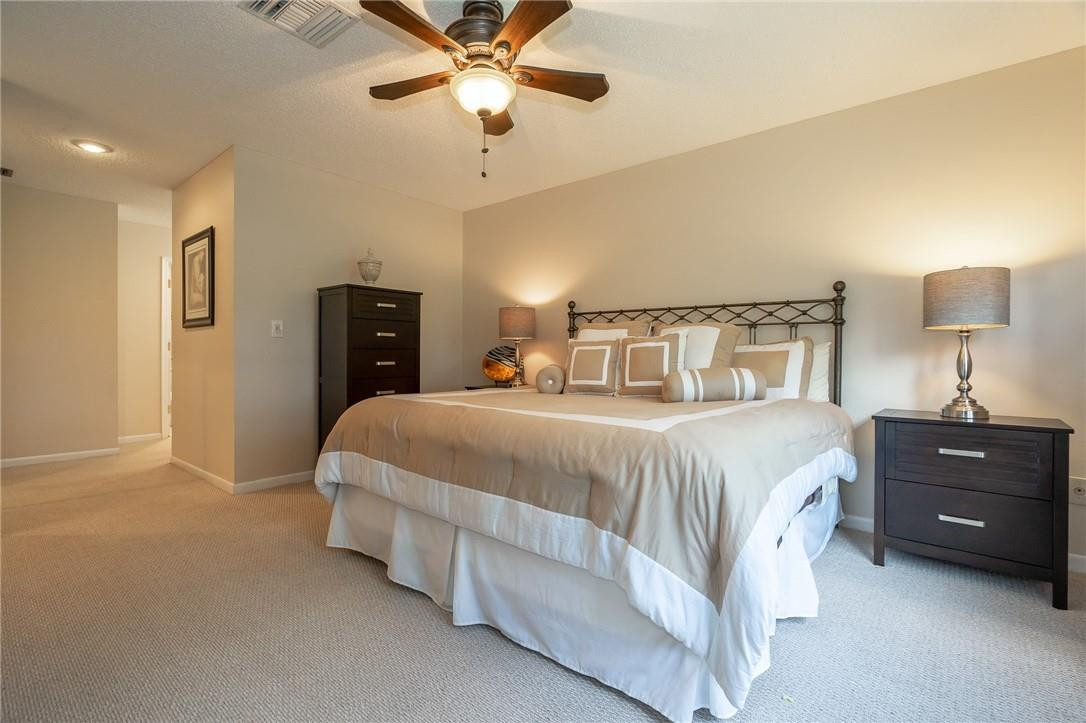 21650 Juego Circle, Unit 24F Boca Raton, FL 33433 - Photo 15 of 24 a spacious bedroom with a bed and a lamp