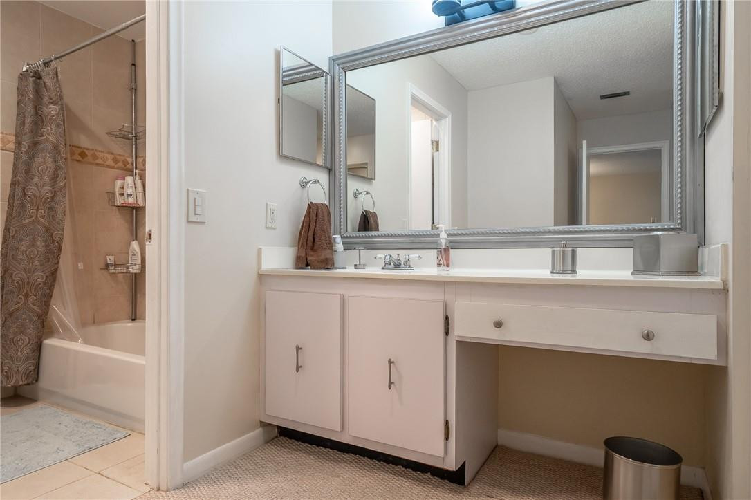 21650 Juego Circle, Unit 24F Boca Raton, FL 33433 - Photo 19 of 24 a bathroom with a double vanity sink a mirror and a bathtub