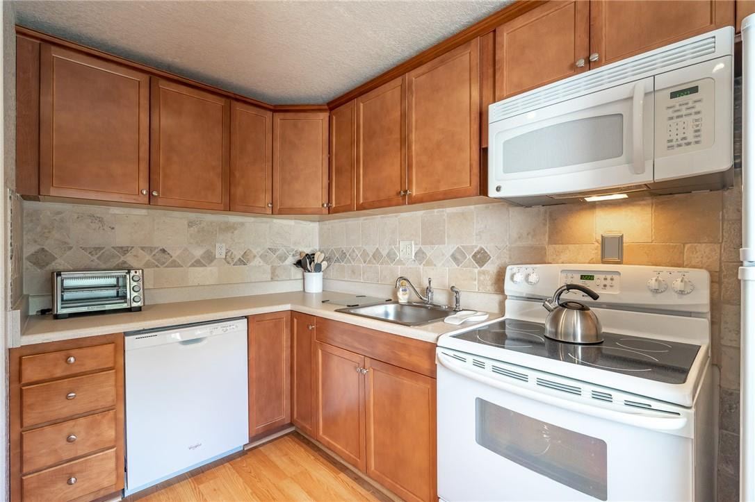 21650 Juego Circle, Unit 24F Boca Raton, FL 33433 - Photo 4 of 24 a kitchen with stainless steel appliances granite countertop a sink stove and cabinets