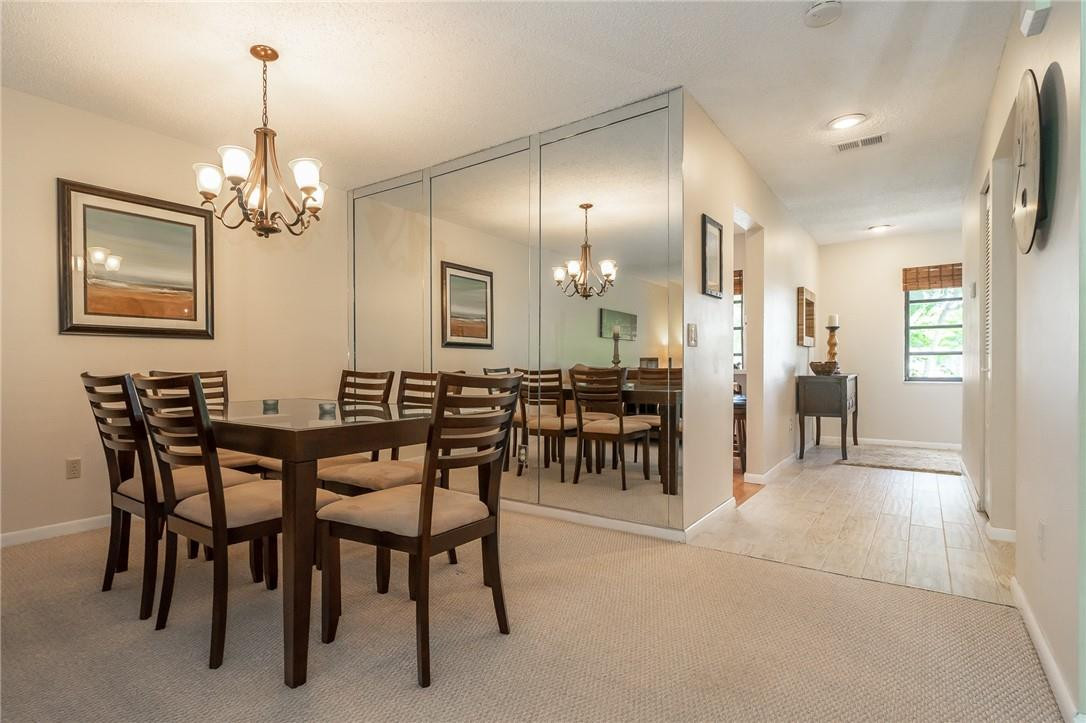 21650 Juego Circle, Unit 24F Boca Raton, FL 33433 - Photo 9 of 24 a view of a dining room with furniture and chandelier