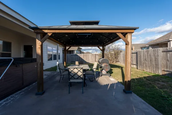 a backyard of a house with table and chairs