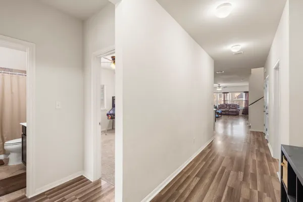 a view of a hallway with wooden floor and staircase