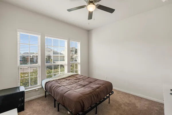 a bedroom with a bed and a large window