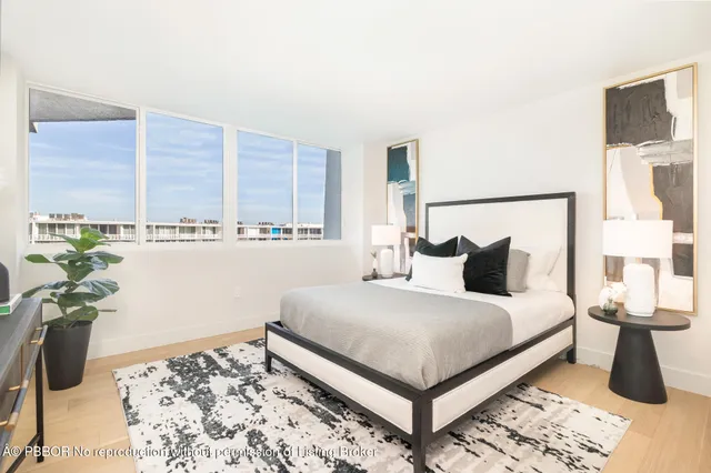 a bedroom with a bed lamp and a potted plant