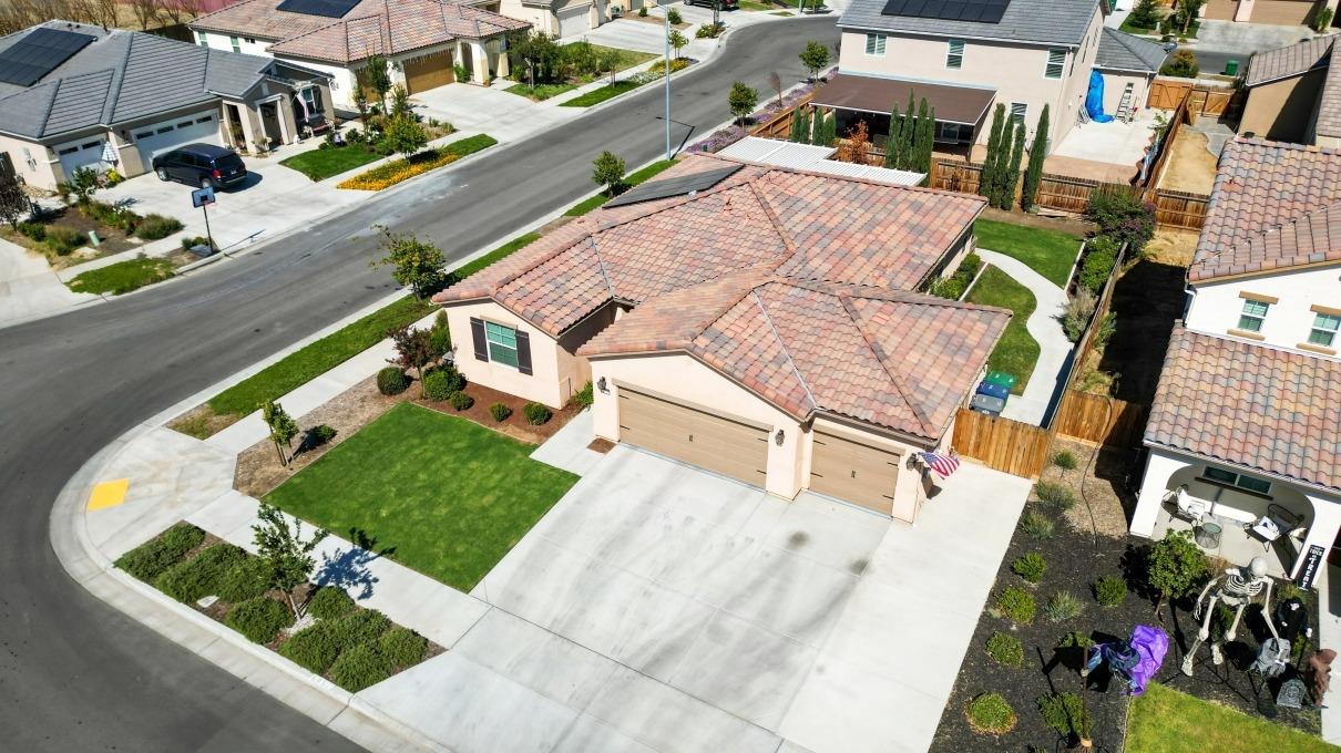 an aerial view of a house with a garden and lake view