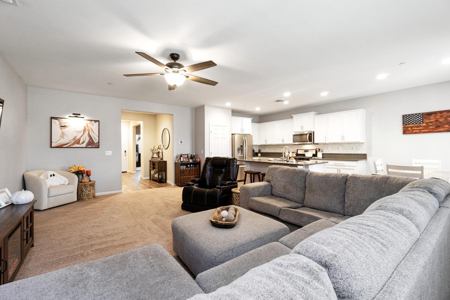 14340 West David Avenue Kerman, CA 93630 - Photo 12 of 30 a living room with furniture kitchen view and a chandelier