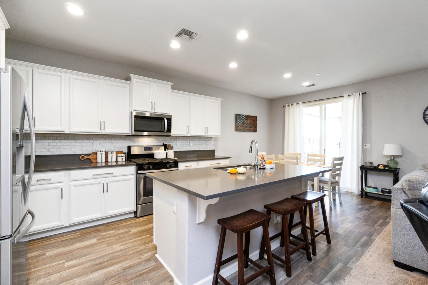 14340 West David Avenue Kerman, CA 93630 - Photo 14 of 30 a kitchen with white cabinets stove and kitchen island