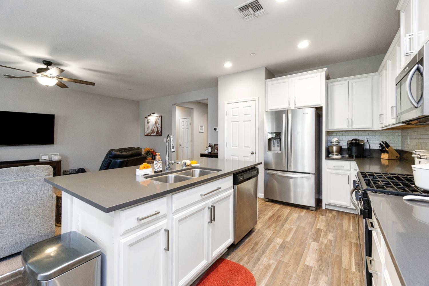 14340 West David Avenue Kerman, CA 93630 - Photo 16 of 30 a kitchen that has a lot of cabinets a sink and appliances
