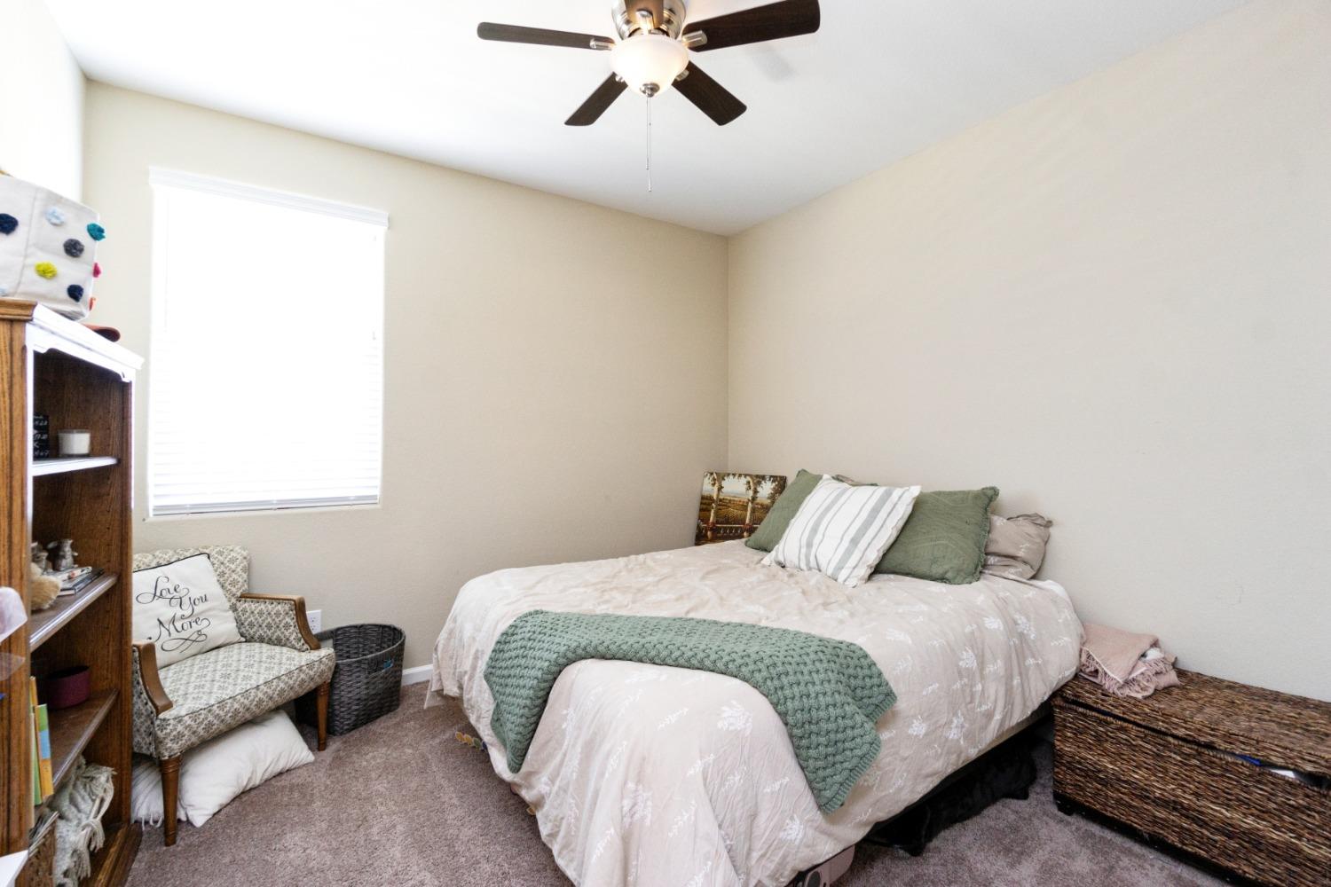 14340 West David Avenue Kerman, CA 93630 - Photo 20 of 30 a bedroom with a bed and a chandelier