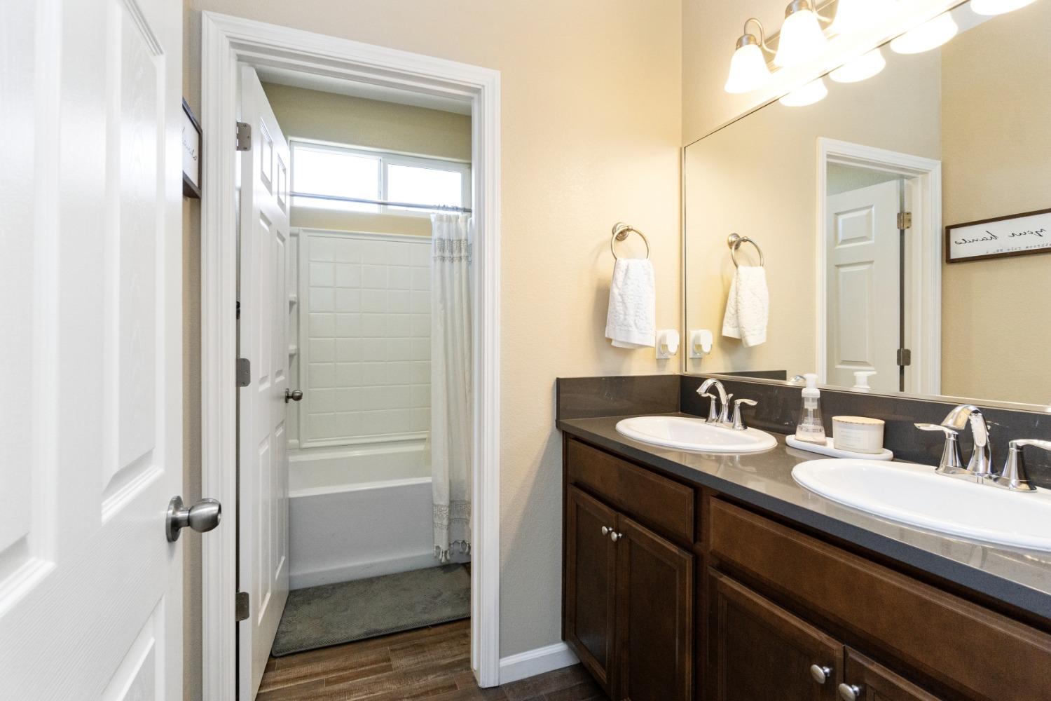 14340 West David Avenue Kerman, CA 93630 - Photo 22 of 30 a bathroom with a double vanity sink a mirror and a shower