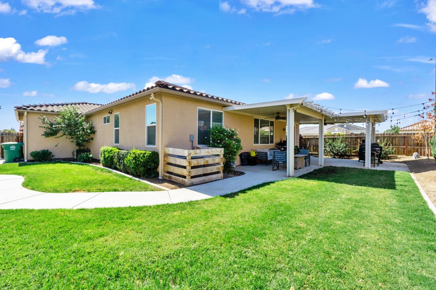 14340 West David Avenue Kerman, CA 93630 - Photo 28 of 30 a yellow and red house with a garden