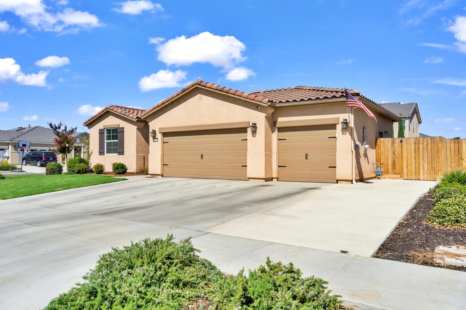 14340 West David Avenue Kerman, CA 93630 - Photo 7 of 30 a front view of a house with a yard and garage