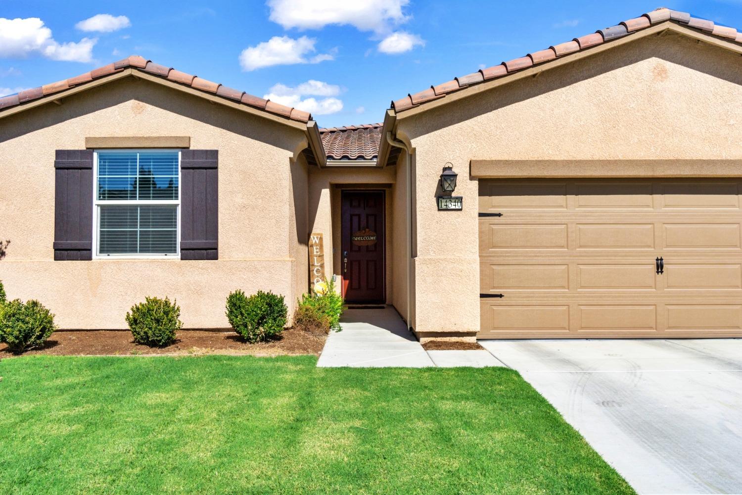 14340 West David Avenue Kerman, CA 93630 - Photo 8 of 30 a front view of a house with a yard