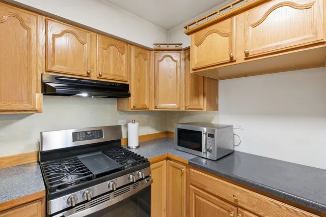 a kitchen with stainless steel appliances granite countertop a stove and a microwave