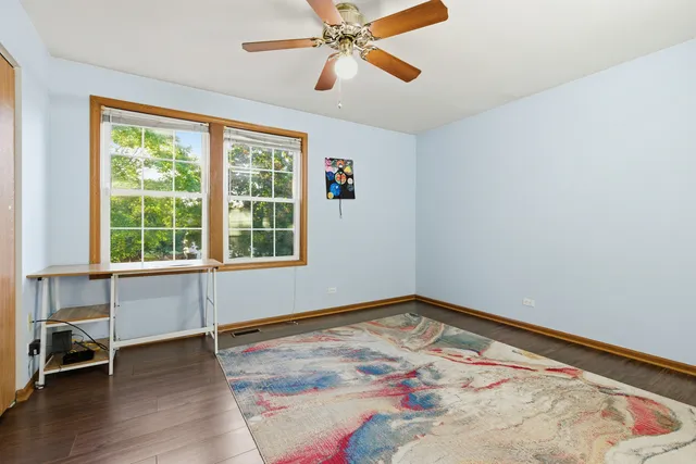 a view of a livingroom with wooden floor and a ceiling fan