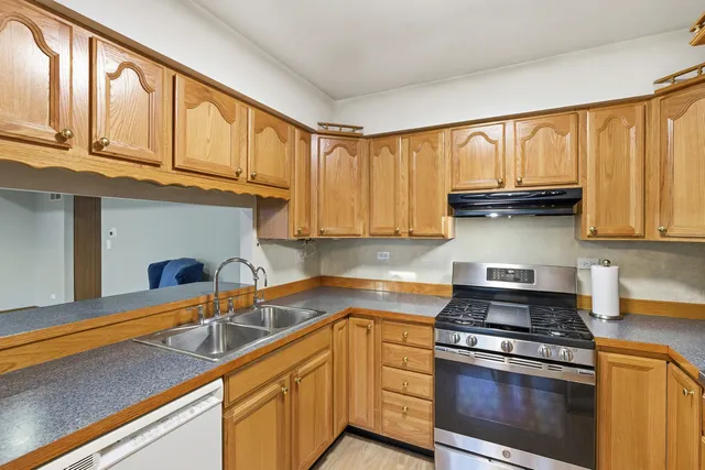 a kitchen with stainless steel appliances granite countertop a sink a stove and cabinets