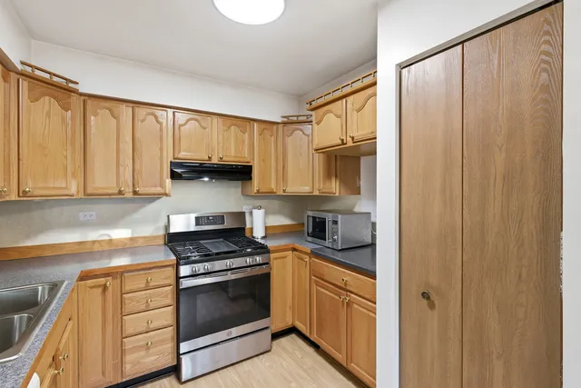 a kitchen with granite countertop white cabinets and white appliances