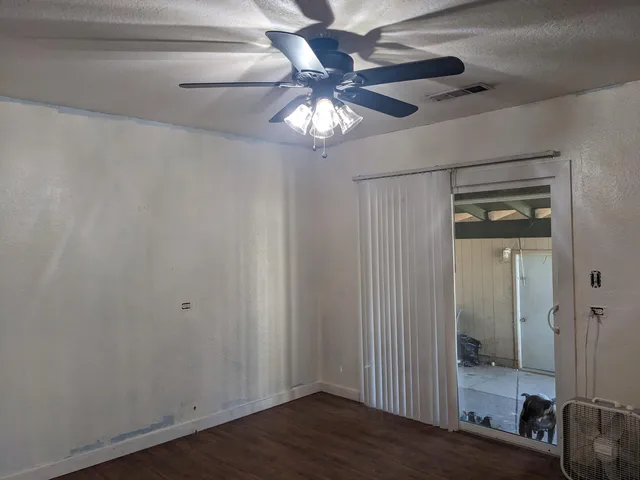 a view of a hallway with wooden floor and a ceiling fan