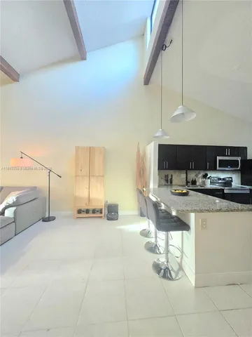 a kitchen with stainless steel appliances kitchen island granite countertop a sink and cabinets