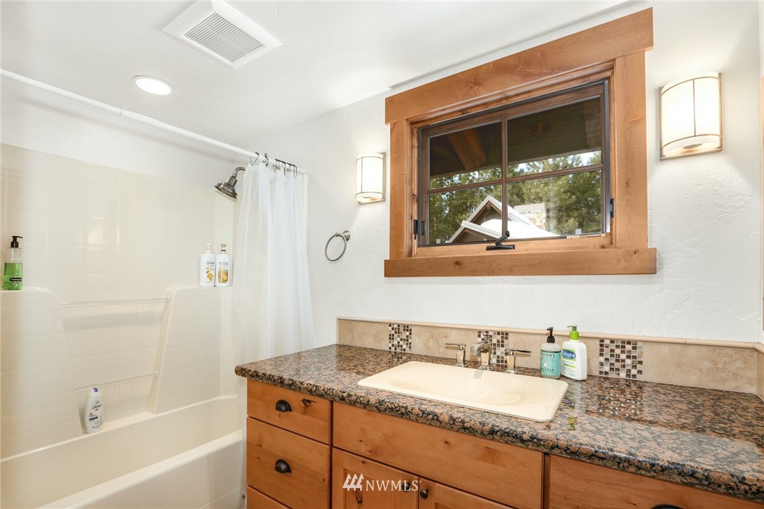 51 Rushing Water Lane Cle Elum, WA 98922 - Photo 23 of 28 a bathroom with a granite countertop tub a sink and mirror
