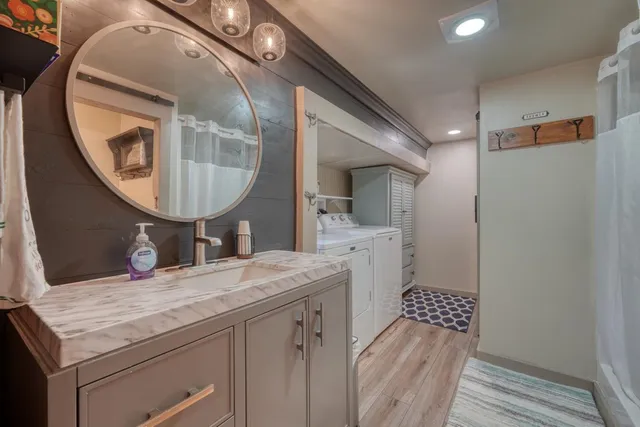 a bathroom with a granite countertop sink a mirror and a shower