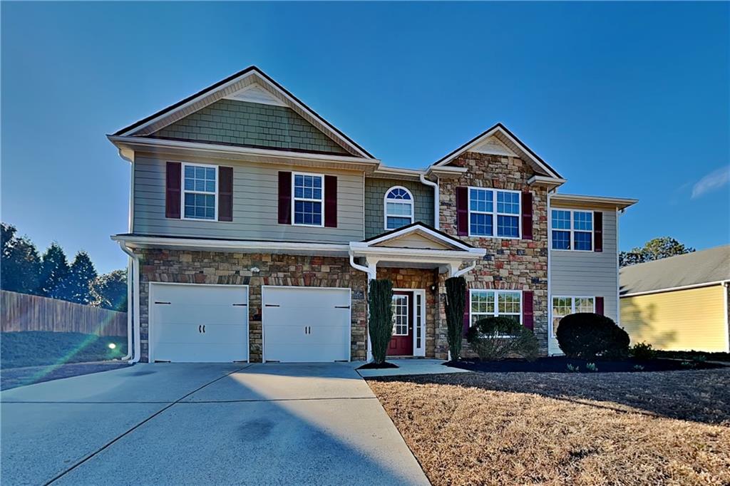 a front view of a house with a yard and garage
