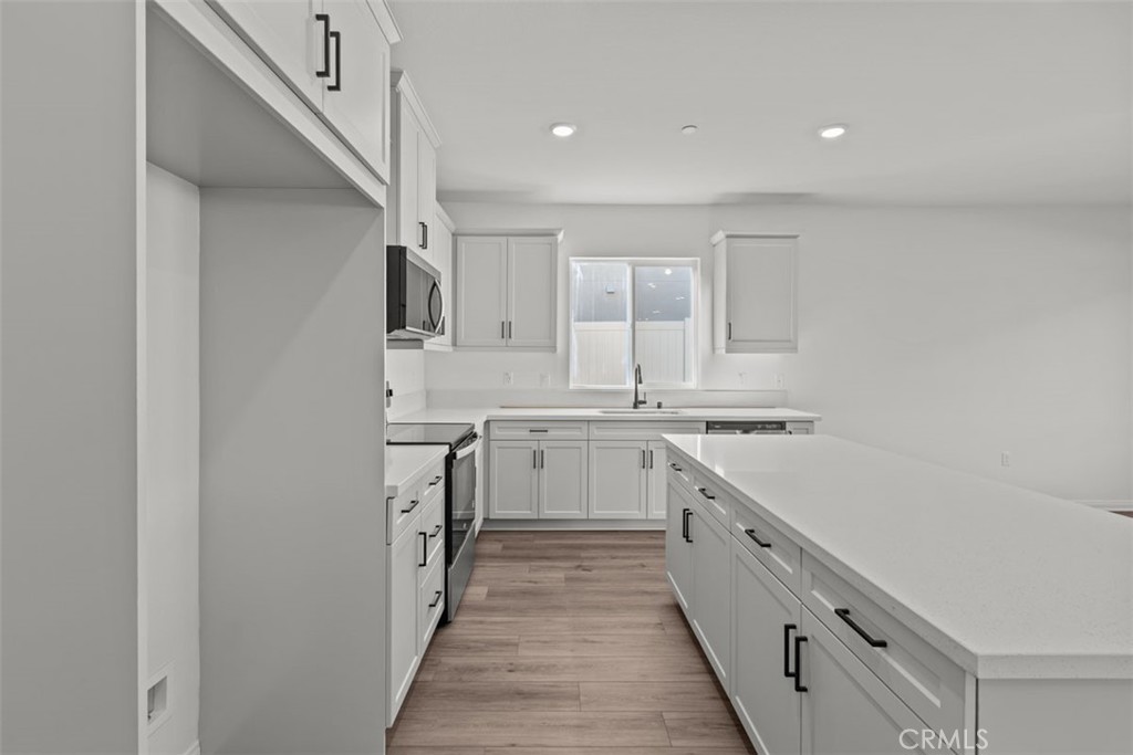 1213 Butterfly Way Banning, CA 92220 - Photo 5 of 18 a kitchen with white cabinets appliances and a sink