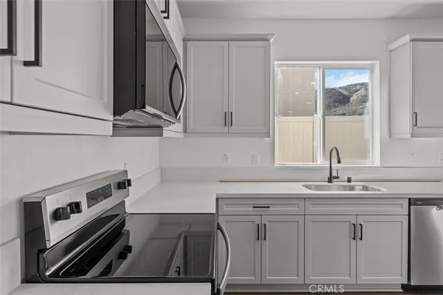 a kitchen with white cabinets and sink