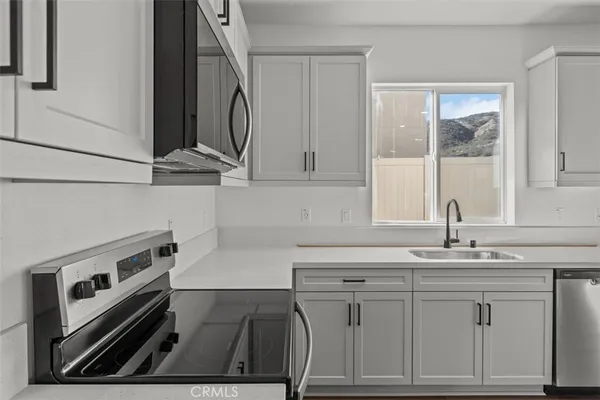 a kitchen with white cabinets and sink