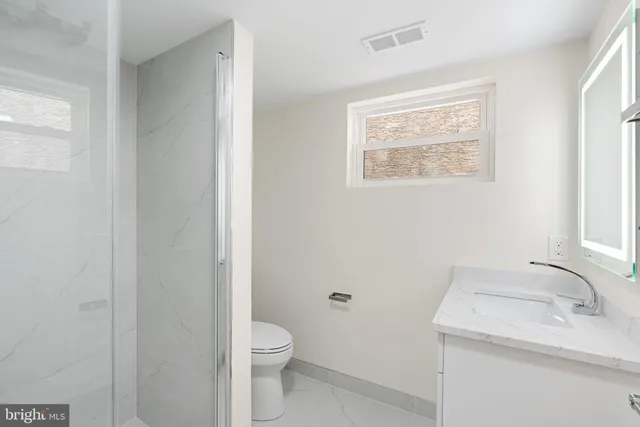a white toilet sitting next to a bathroom sink