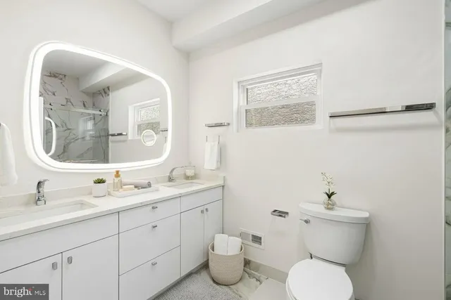 a bathroom with a toilet sink and mirror