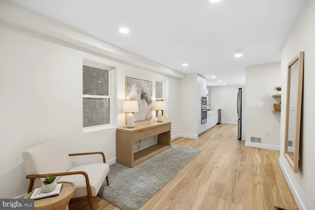 a large white room with wooden floor and furniture