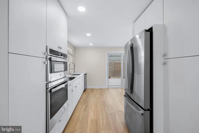 a kitchen with stainless steel appliances granite countertop a refrigerator and a stove top oven