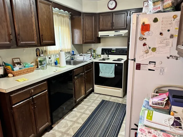 a kitchen with stainless steel appliances a sink a stove a refrigerator and cabinets