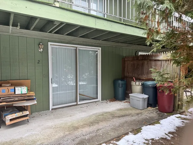a view of a patio with couple of chairs and a barbeque