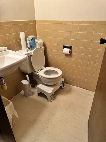 a bathroom with a toilet a sink and a mirror