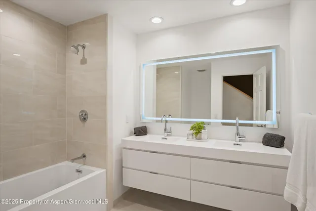 a bathroom with a bathtub sink and mirror