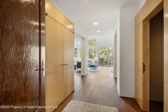 a view of a hallway with wooden floor and staircase