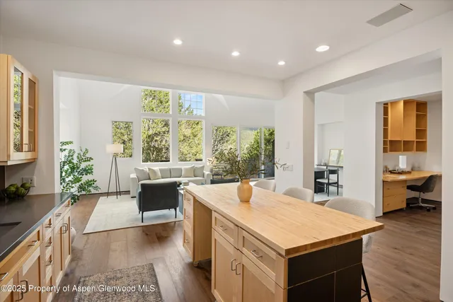 a living room with stainless steel appliances granite countertop furniture and a large window