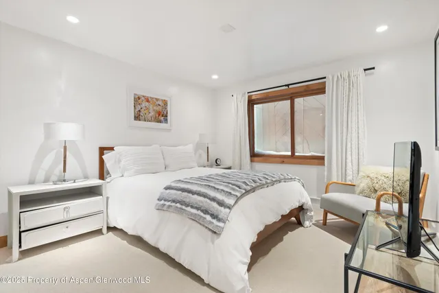 a bedroom with a bed and large window