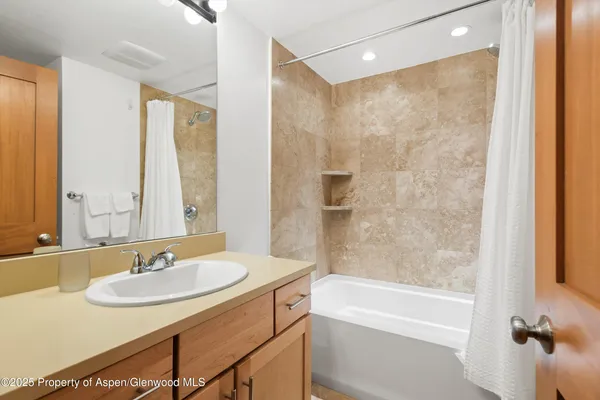 a bathroom with a sink double vanity granite tub shower and a mirror