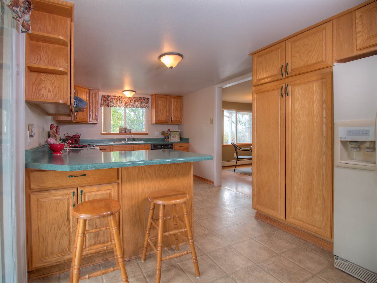 1754 L L 1/2 Road Fruita, CO 81521 - Photo 9 of 22 a kitchen with granite countertop a refrigerator and cabinets