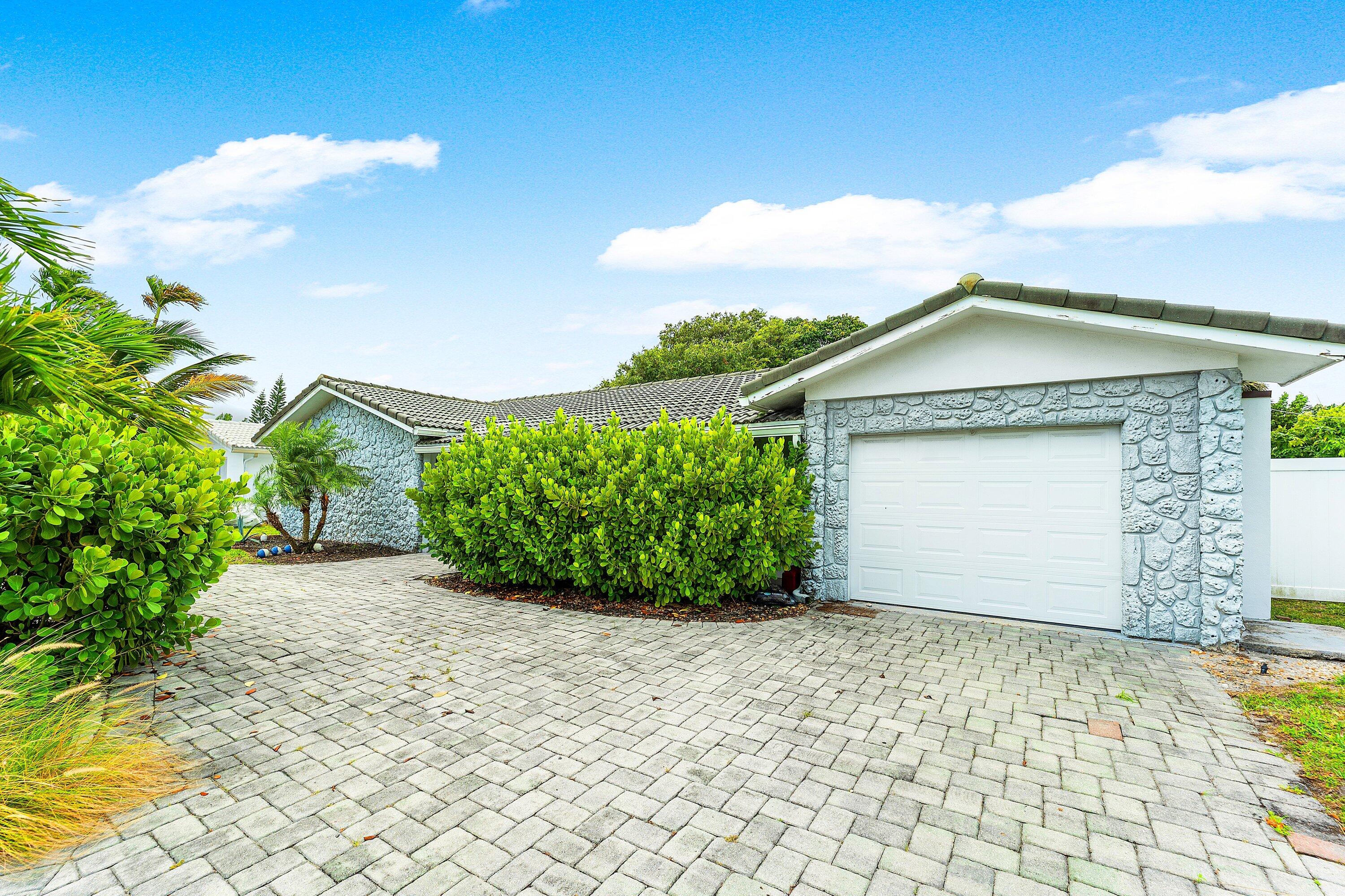 581 Northwest 13th Drive Boca Raton, FL 33486 - Photo 4 of 39 a front view of a house with a garden