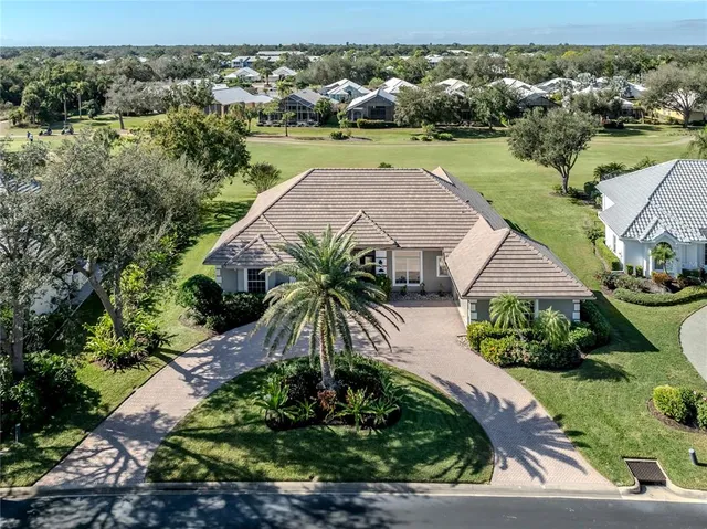 an aerial view of a house with a yard and lake view