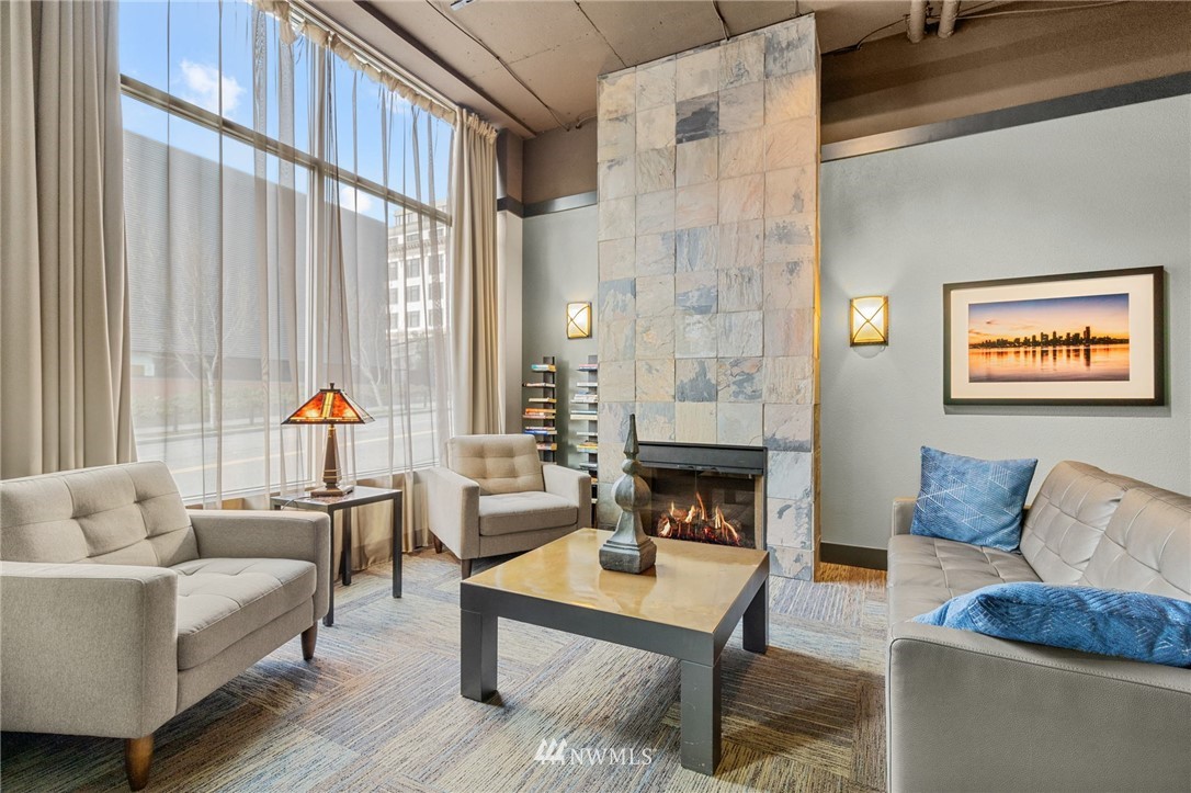 108 5th Avenue South, Unit 710 Seattle, WA 98104 - Photo 12 of 22 a living room with furniture a fireplace and large window