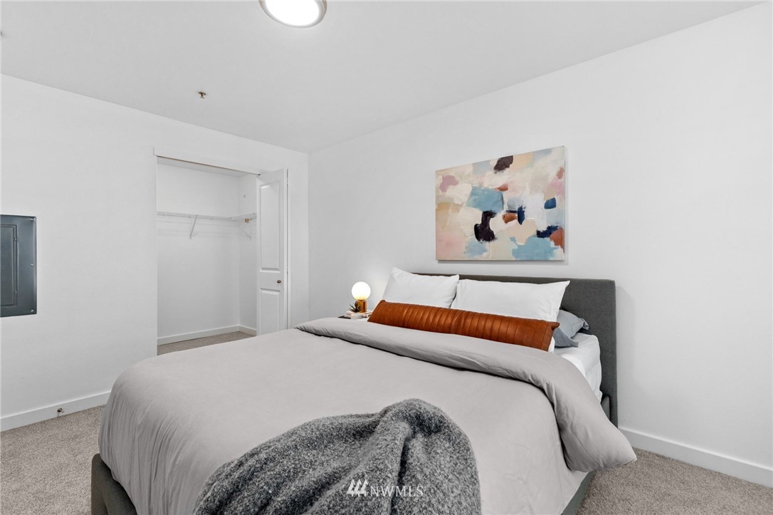 108 5th Avenue South, Unit 710 Seattle, WA 98104 - Photo 9 of 22 a bedroom with a bed and painting on the wall